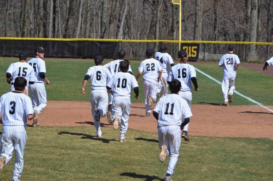 The Baseball team jogs during their game against Riverdale.