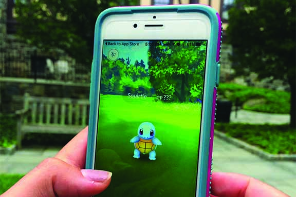An avid Pokémon player catches a Squirtle in the Courtyard at Hackley.