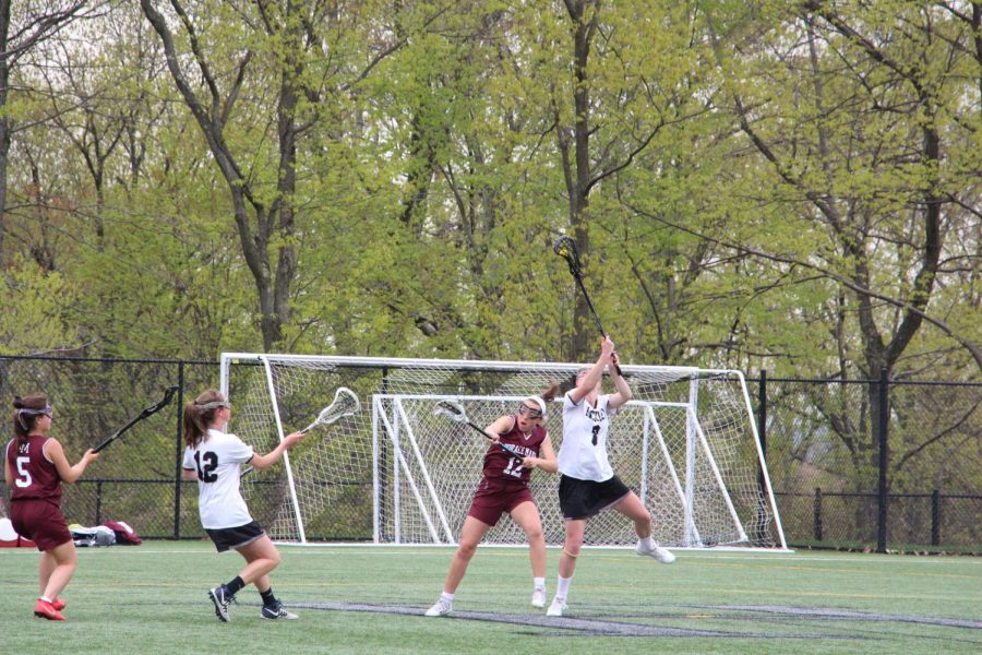 Junior midfielder Julia Thomson reaches to win the draw. Thomson uses her speed and height to her advantage in dominating Horace Mann.