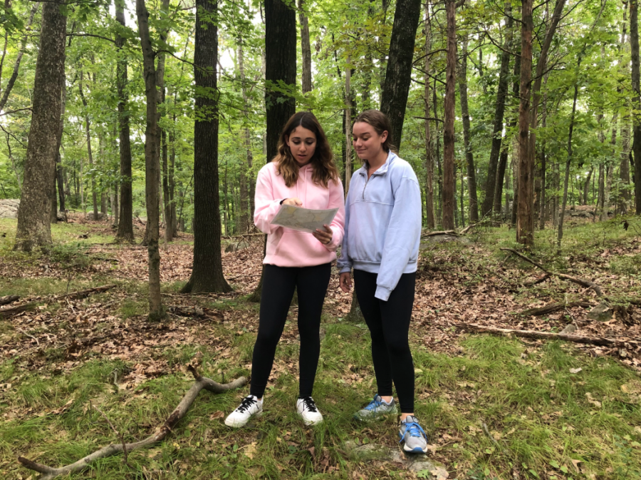 Sophomores Logan Oscher and Hannah Carrey attempt to find the next number of their scavenger using their map of Tea Town. Students were left with only compasses and maps as they explored the woods and looked for the next number in their hunt. 