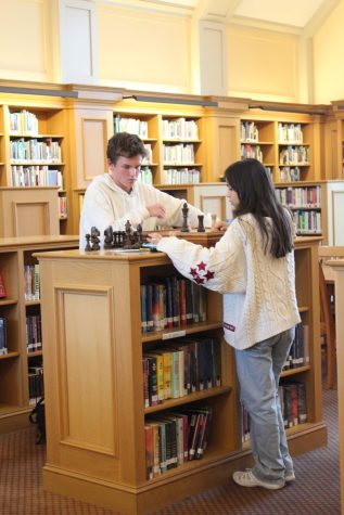 Hunter Chapman ‘26 and Gabriela Nunes ‘26 focus on their game of chess in the library.