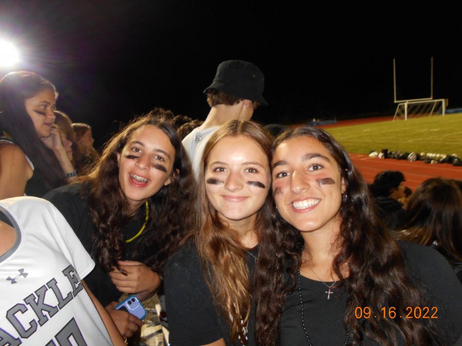 Sophomores Donia Karandikar, Maggie Yalmokas, and Alessia Sorvillo show their school spirit by wearing all black. Standing towards the back of the crowd did not stop them from cheering loudly for the boys varsity soccer team.