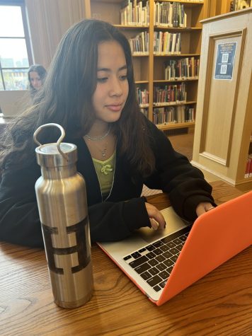 Sophomore Isabella Barriera works on her English project in the library, her water bottle next to her. Every year, HEAL passes out these water bottles to the freshmen so everyone has access to a reusable water bottle.