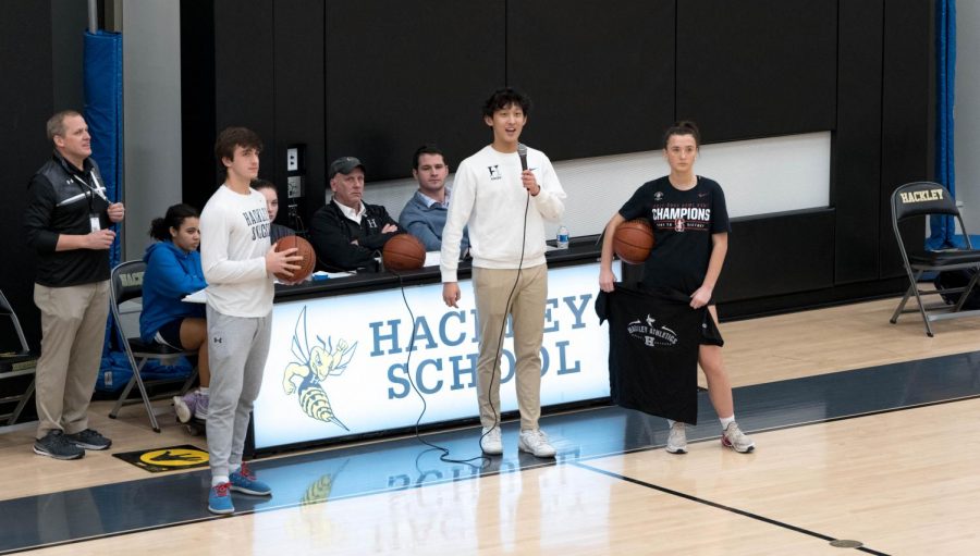 Steven Li, President of the Upper School,  helps run the halftime event during the girls varsity basketball game. The winners of the shooting competition received a Hackley T-shirt.