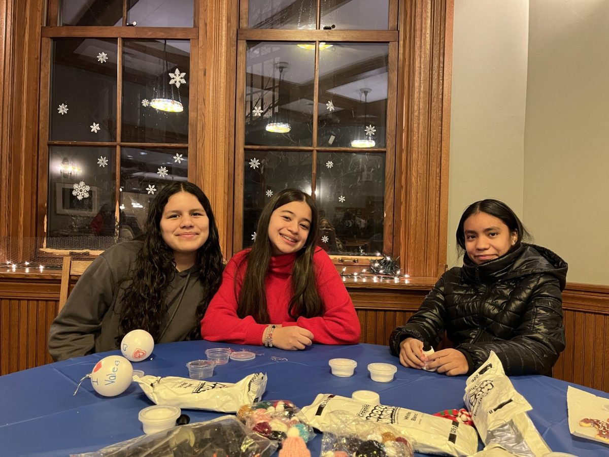 Eighth grade Scholars gather at a table making crafts alongside their decorated ornaments. Several different activities were set up for the Scholars to participate in. This Holiday Party is an annual tradition allowing Scholars and their families to connect with Hackley mentors and faculty. 