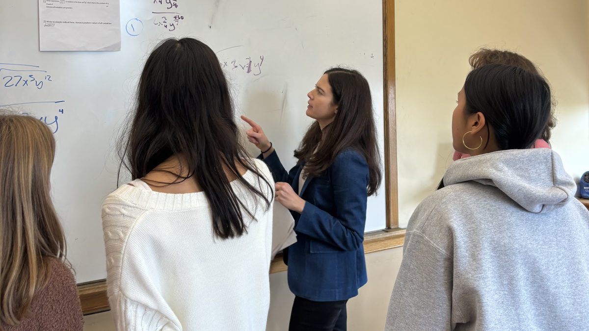 Ms. Bodner helps a group of students solve an equation. This moment was captured in her Accelerated Algebra 2 class where Ms. Bodner split the students up into groups and had them solve algebraic equations. She is showing her excitement to encourage students in their math journeys.