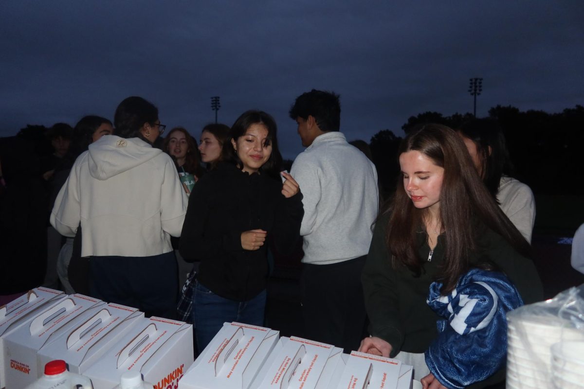 Seniors Rebecca Ingles and Gabrielle Diaz-Alcantara pour themselves Dunkin' coffee to help wake themselves up. Community council provided the coffee and hot chocolate. There were a lot of beverages and pastries left over, so they were brought to the Senior Lounge for anyone to enjoy.