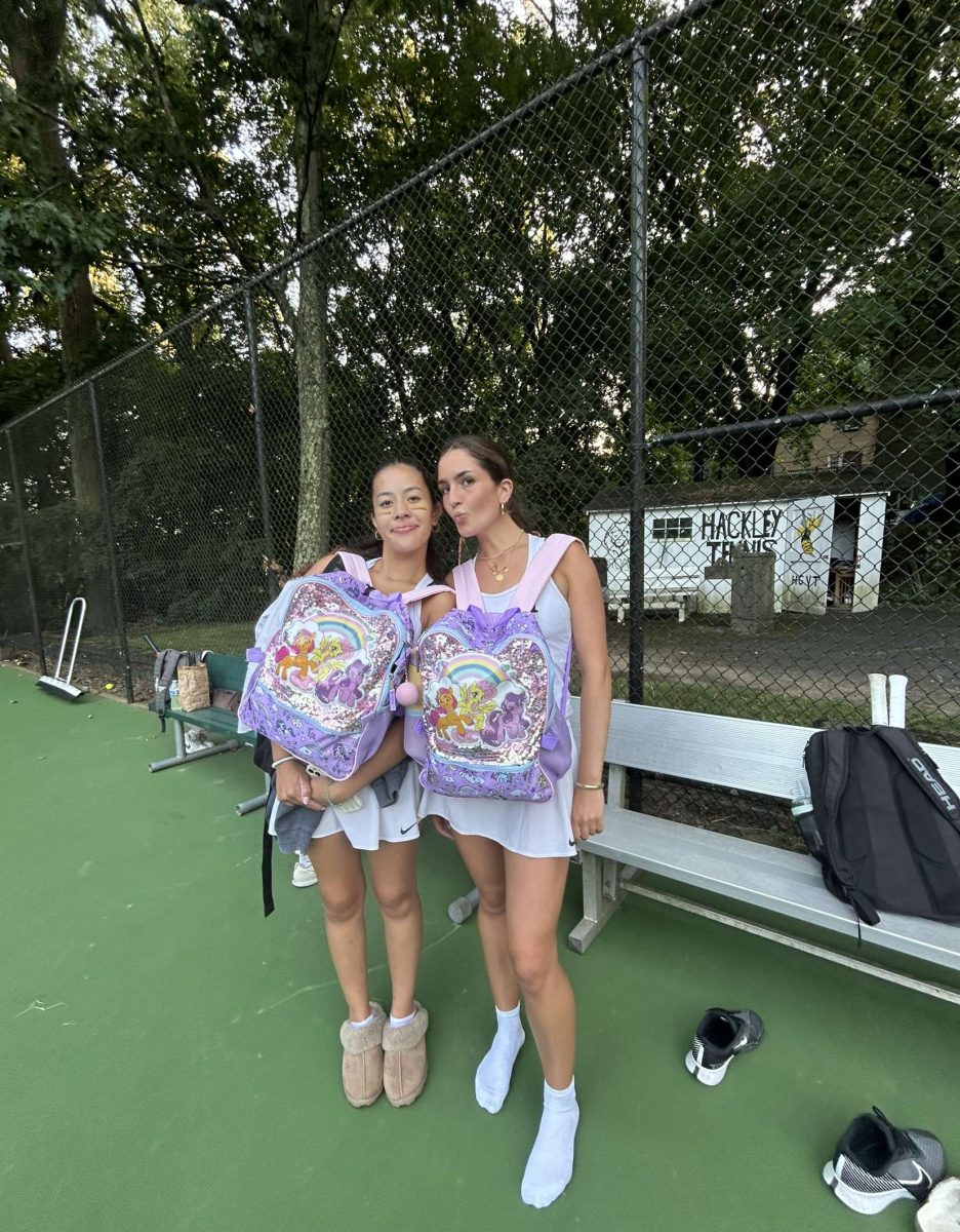 Senior tennis captains Isabella Barriera and Frances Clifford showcase their matching My Little Pony backpacks on the tennis courts. This fun activity allowed some to team up with friends and match with them. Their coordinated backpacks show the friendship and spirit shared among the senior athletes.