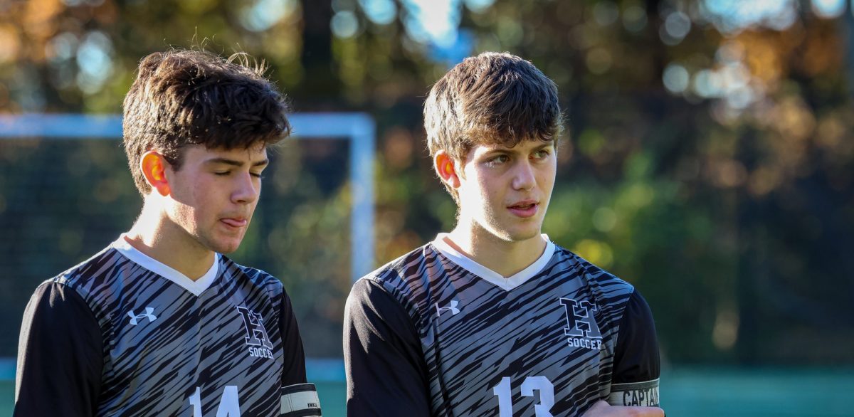 Captain Jack Perlman and Tyler Mook standing together on the field during their Senior Day game versus Dalton. The captains talk with the referee before the game and decide who starts with the ball and which side of the field they start on.