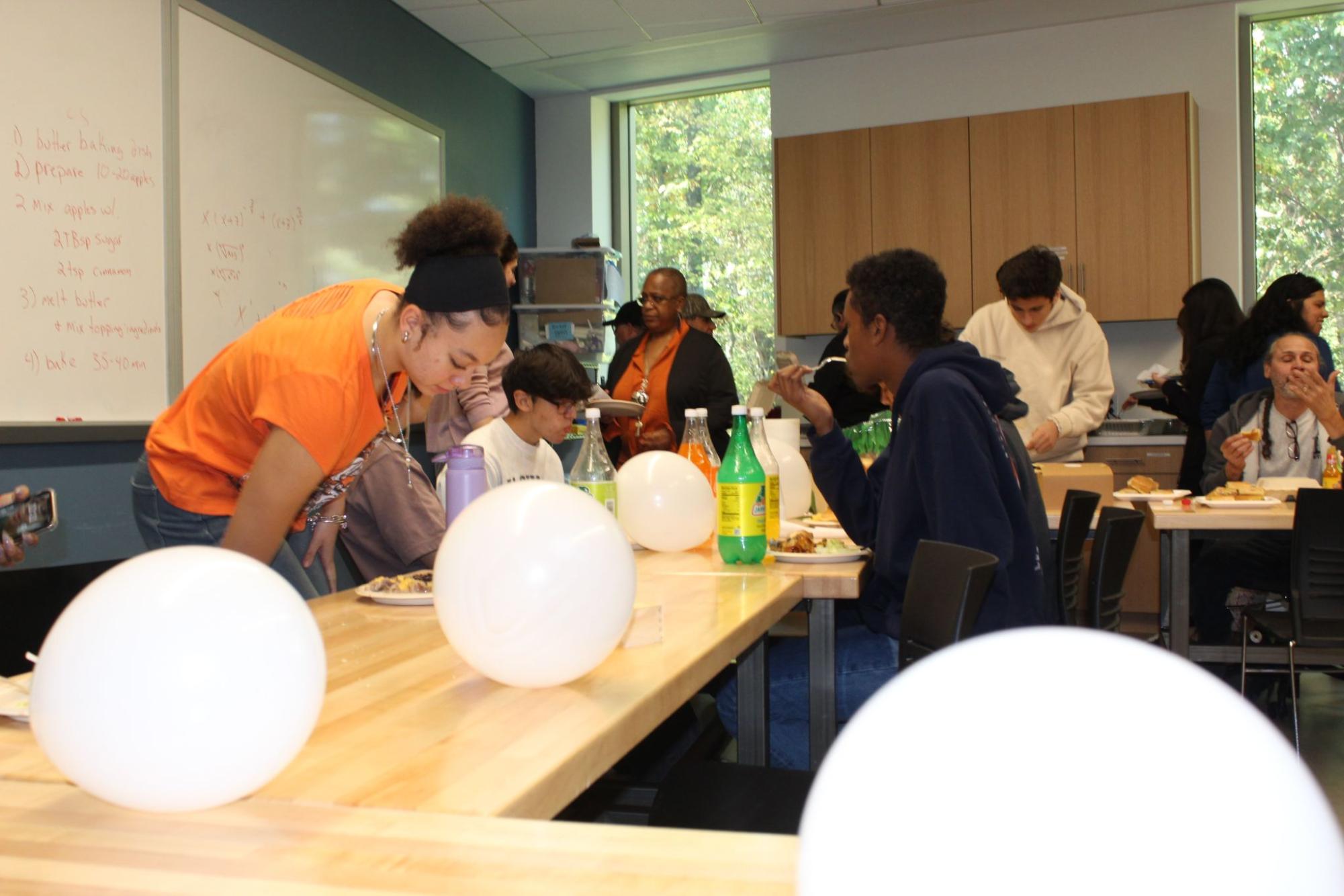 Students and staff gathered in the Johnson Center, where white balloons decorate the space for Hispanic Heritage Month. They shared stories, laughter, and traditional dishes, which created a warm and welcoming atmosphere. The lunch was a chance for the community to celebrate their shared heritage and strengthen their connections.