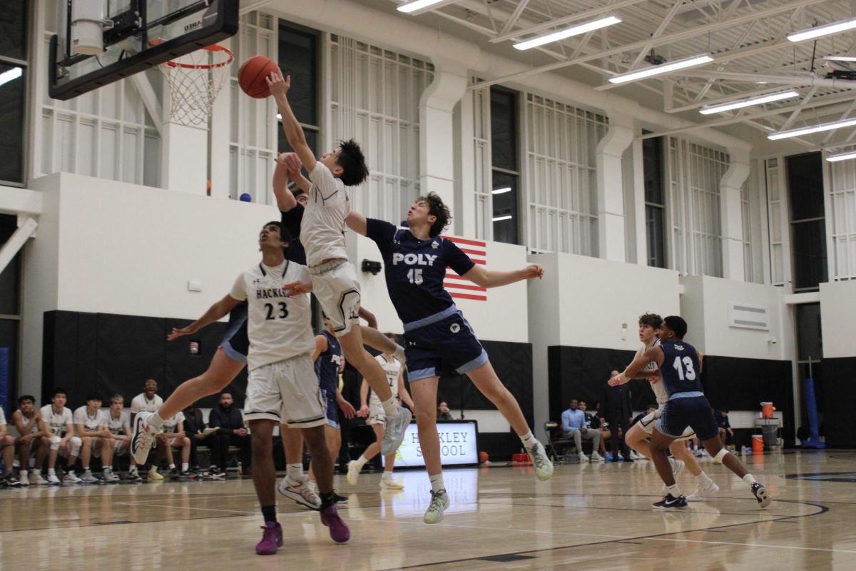 Sophomore Alex Nuzum goes up for a layup in an intense game against their rival, Poly Prep. The Boys' Varsity Basketball team had a tight game, ending in a 67-58 loss.