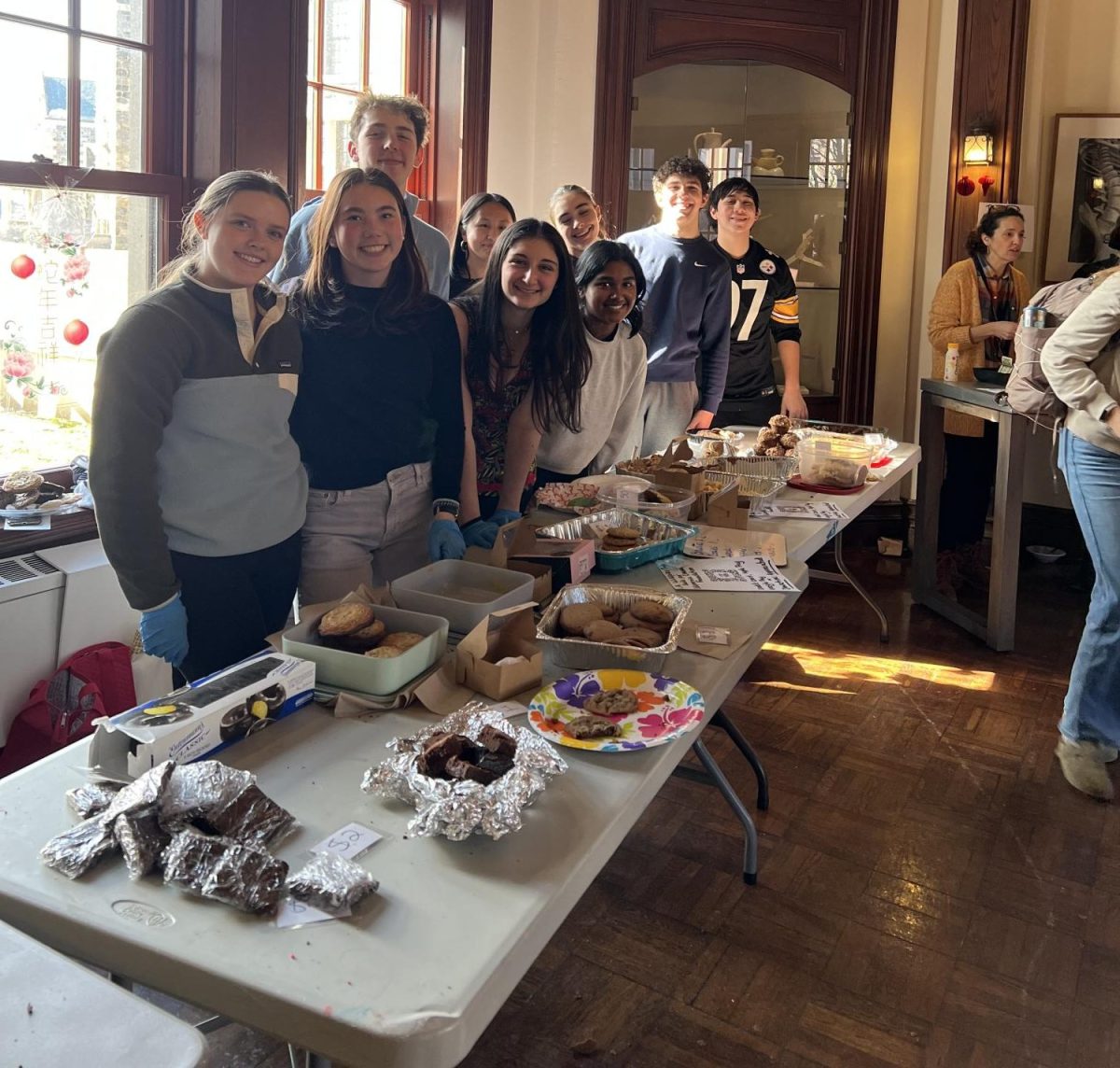 Sophomore volunteers Lily Rodgers, Sophie Kim, Owen Spencer, Lilly Rosenthal, Emi Dotter Se, Gabrielle Paes, Caitlin Morrow, Josh Gandelman, and Tyler Stern (left to right) all came during Upper School lunch to help out and work the bake sale table, selling nearly every baked good.