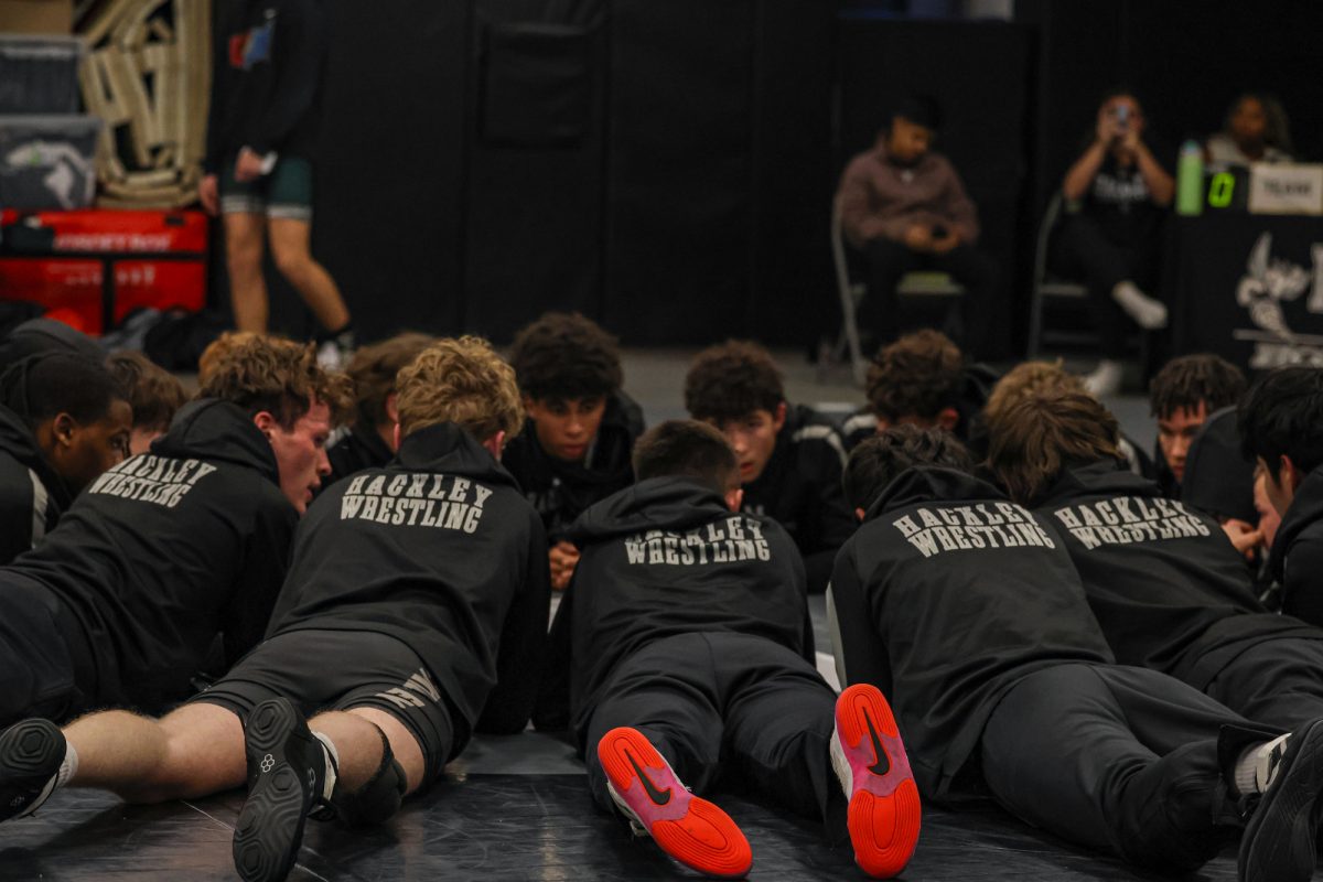 The Wrestling Team warms up for their match. They huddle in a circle in preparation to get excited before their match.