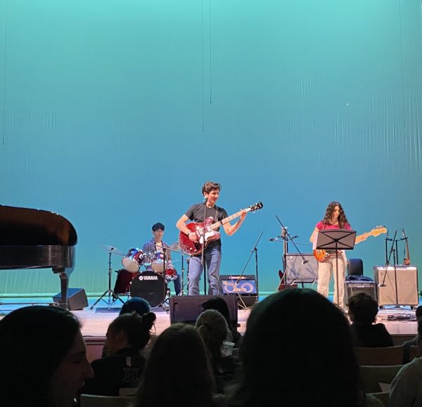 Ace preforming his song "Alien" for the first time at Coffeehouse along with sophomores Pierce Roc-Sennett and Mai Malkiel. The crowd watches in awe as Ace shows off his musical talents, using both his voice and the guitar.