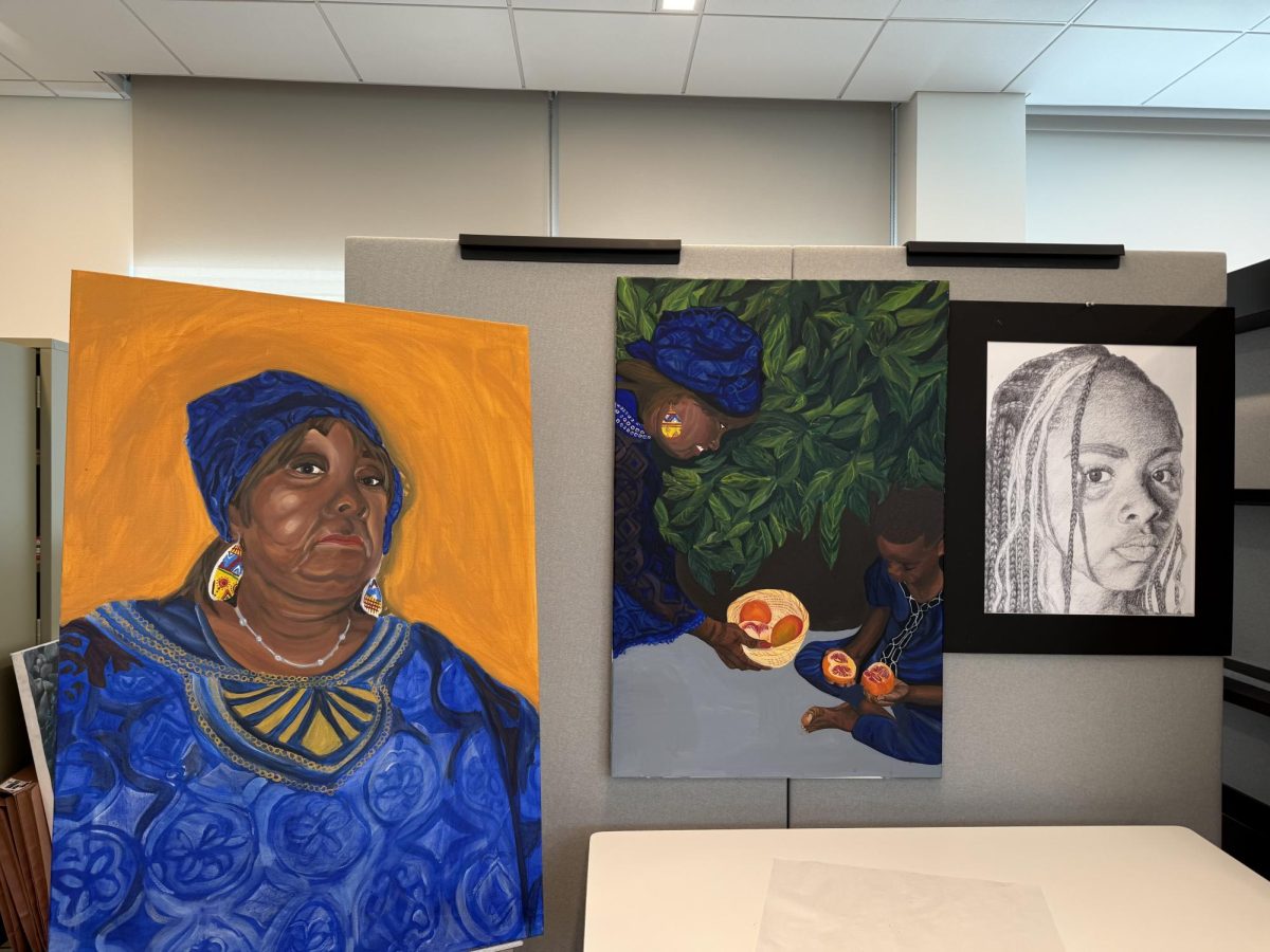 Senior Nkechi Ude's concentration focuses on how clothing can represent who people are. These three photos are featured in her cubicle in the AP art studio. The photo may seem like just a woman wearing a blue shirt, but that blue shirt has more meaning to it, which represents a part of who she is.