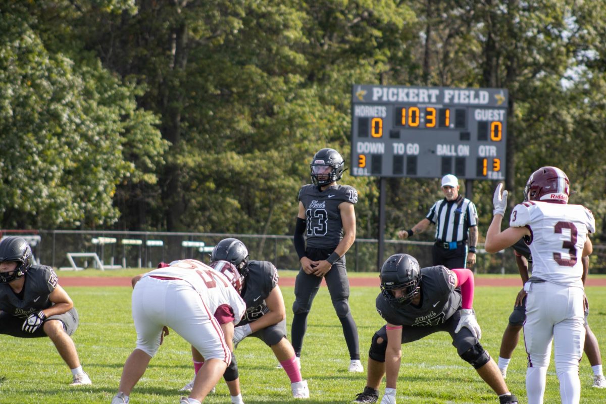 Hackley's quarterback scans the defense before the snap, embodying the team's focus in pivotal moments. Every play reflects the determination and preparation that define Hackley Football's approach. With sharp concentration and discipline, the Hornets work to turn strategy into execution on the field. 