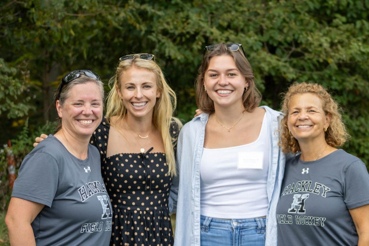 Head Coach Jennifer Leffler and Coach Carolyn Gaven take a photo with former Field Hockey alums before the start of the game.